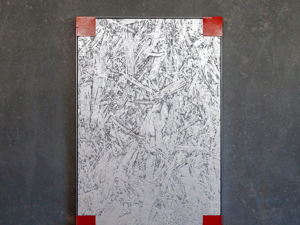 Post Animalism: a brushed aluminium panel with a cast claw form and a small red square, mounted on concrete