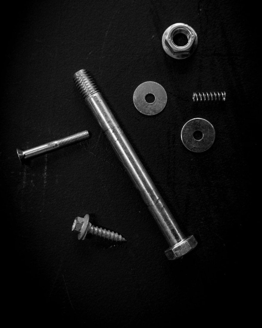 Bolts, washers and fasteners laid out on a black surface